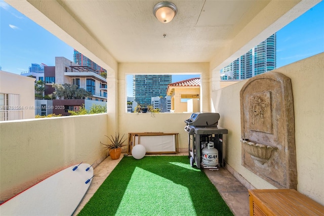 view of patio / terrace with a view of city, a balcony, and area for grilling