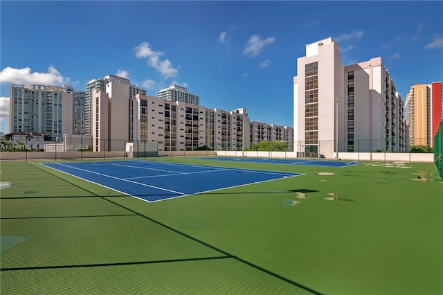 view of sport court with community basketball court, a view of city, and fence