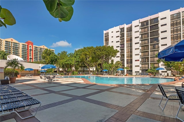 community pool with a patio and fence