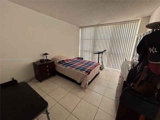 bedroom featuring light tile patterned floors and a textured ceiling