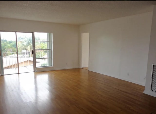 empty room featuring a textured ceiling and wood finished floors