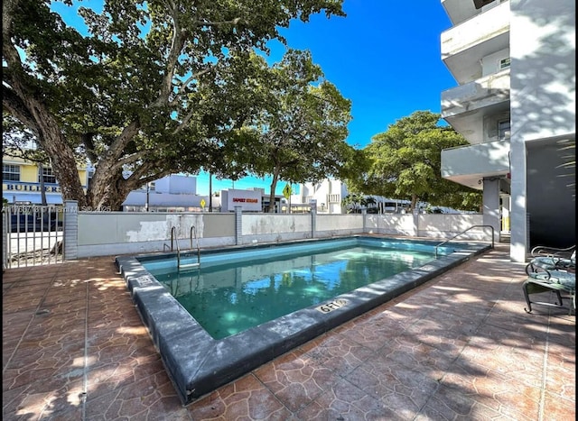 pool featuring a patio and fence