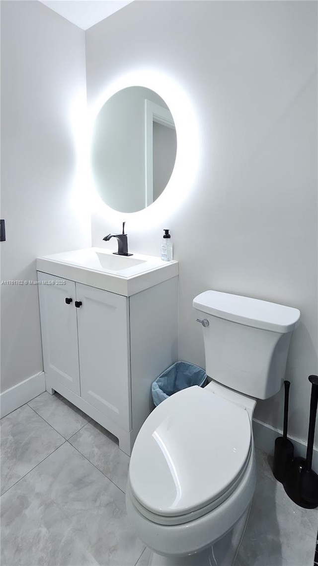 bathroom with baseboards, marble finish floor, vanity, and toilet