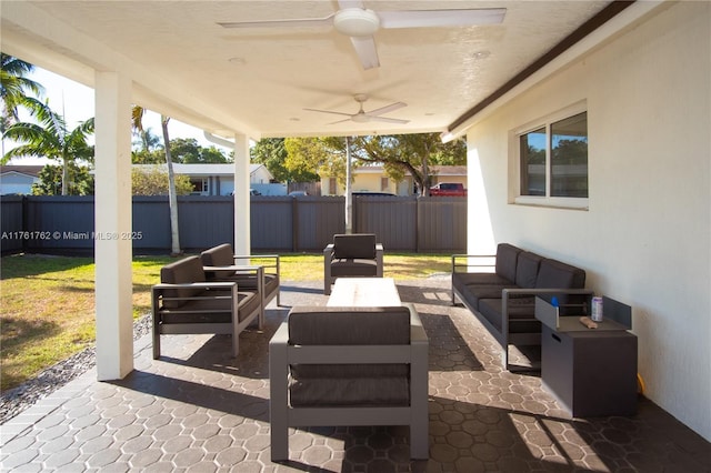 view of patio / terrace with an outdoor living space, a fenced backyard, and a ceiling fan