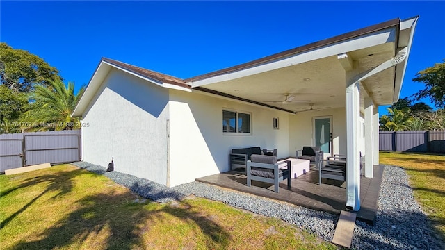 back of house with an outdoor hangout area, a patio, a fenced backyard, a yard, and a ceiling fan