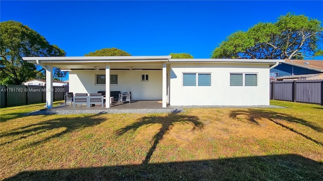 rear view of house with a patio area, a yard, a fenced backyard, and stucco siding