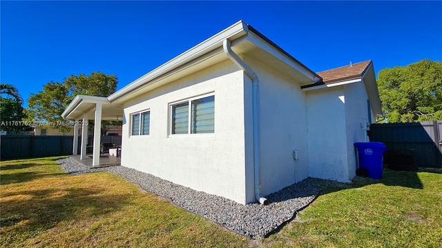 view of home's exterior featuring a yard, fence, and stucco siding