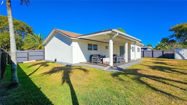 rear view of house with a ceiling fan, a patio area, a fenced backyard, and stucco siding