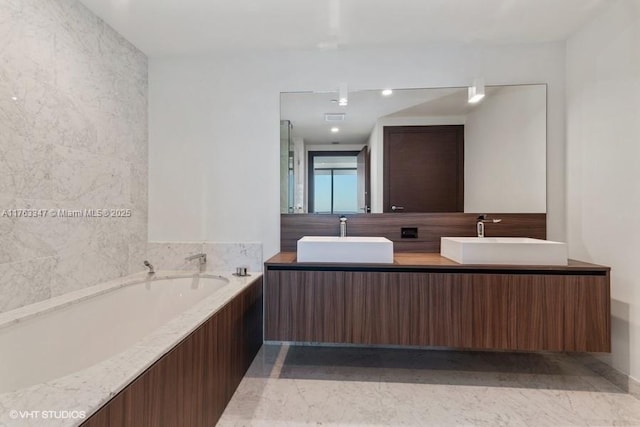 bathroom with a sink, a garden tub, double vanity, and granite finish floor