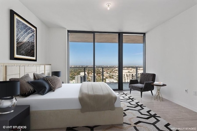 bedroom featuring multiple windows, wood finished floors, baseboards, and expansive windows