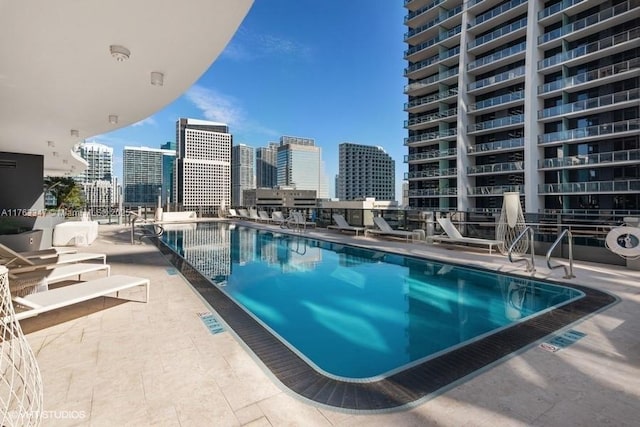 pool with a patio area and a view of city