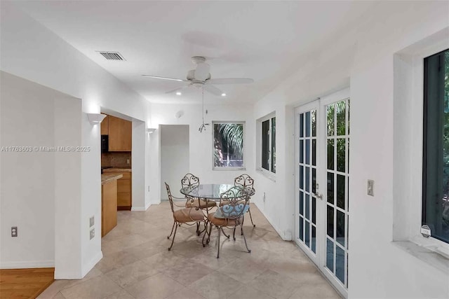 dining area with a ceiling fan, visible vents, and baseboards