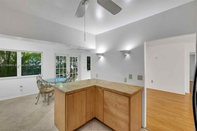 kitchen with light wood-style flooring, a peninsula, french doors, and ceiling fan