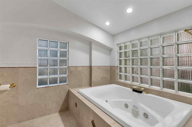 full bathroom with tile patterned floors, recessed lighting, tile walls, and a whirlpool tub