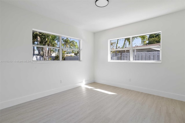 spare room featuring wood finished floors and baseboards