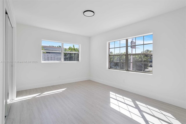 spare room featuring baseboards and wood finished floors