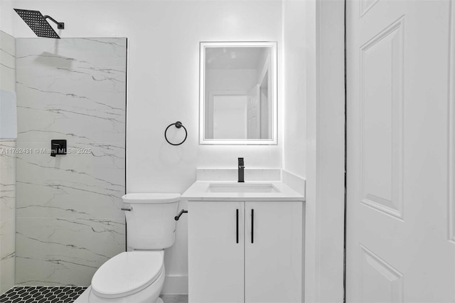 bathroom with a marble finish shower, toilet, and vanity