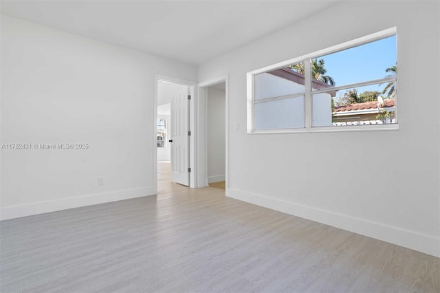 unfurnished room featuring baseboards and wood finished floors