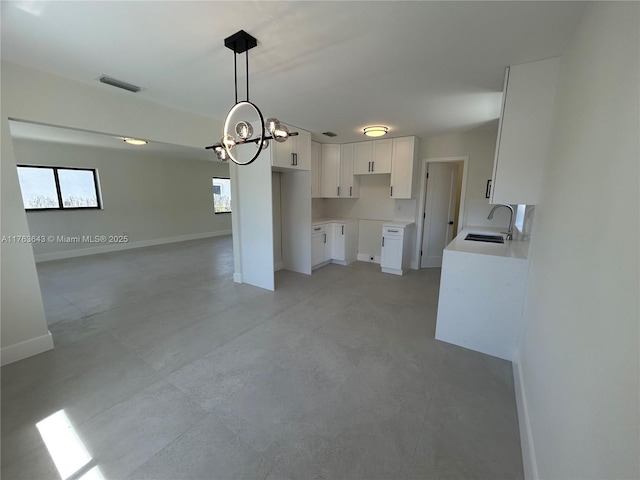 kitchen featuring a sink, a chandelier, open floor plan, visible vents, and white cabinets