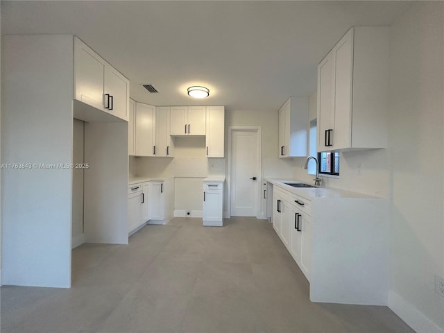 kitchen with visible vents, white cabinetry, and a sink
