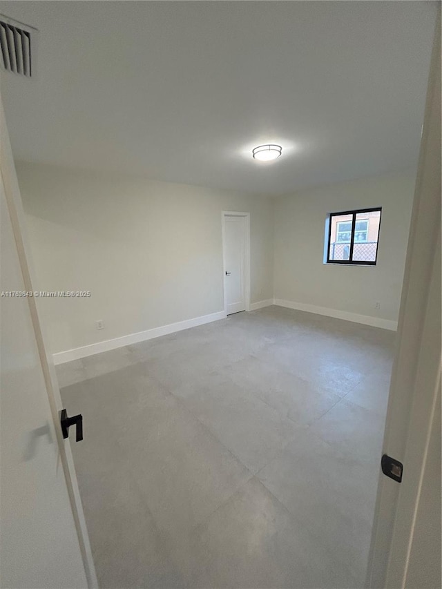 spare room featuring baseboards and visible vents