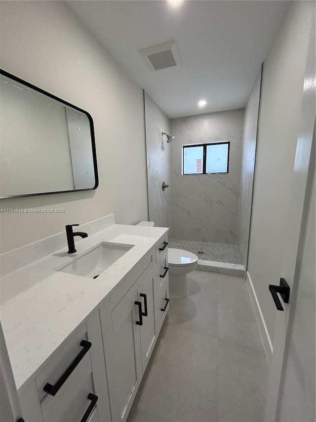 full bathroom featuring visible vents, baseboards, a marble finish shower, toilet, and vanity