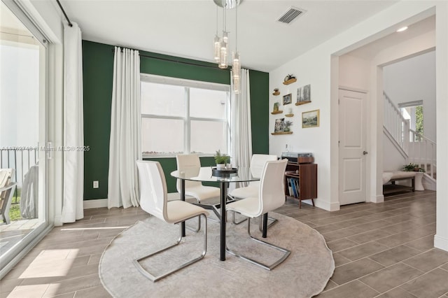 dining room with visible vents, stairs, baseboards, and wood tiled floor