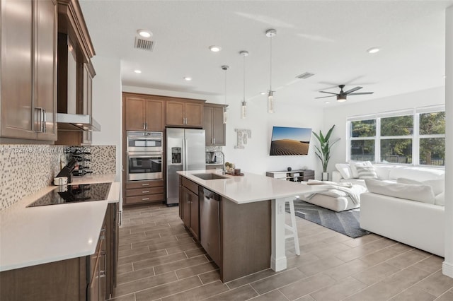 kitchen with ceiling fan, visible vents, backsplash, and stainless steel appliances