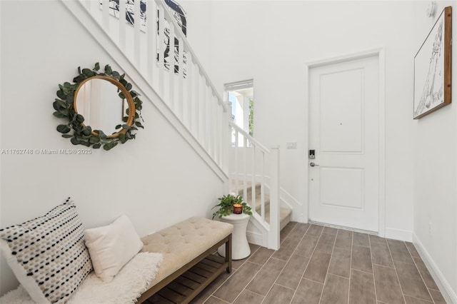 entrance foyer with stairway, baseboards, and wood tiled floor