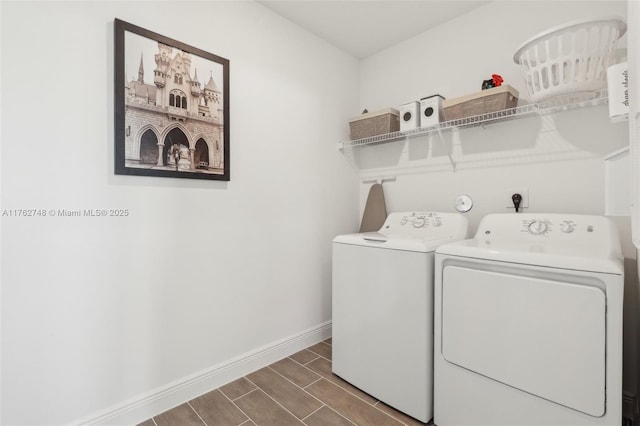 laundry area with baseboards, wood tiled floor, laundry area, and washer and clothes dryer