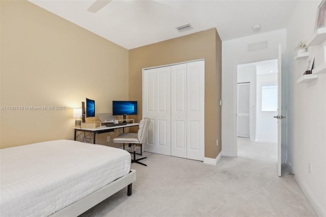 bedroom with visible vents, a closet, baseboards, light colored carpet, and ceiling fan