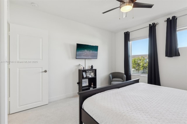 bedroom with light colored carpet, baseboards, and ceiling fan