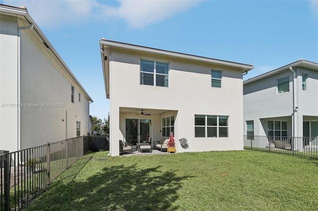 rear view of house featuring a lawn, a fenced backyard, and stucco siding