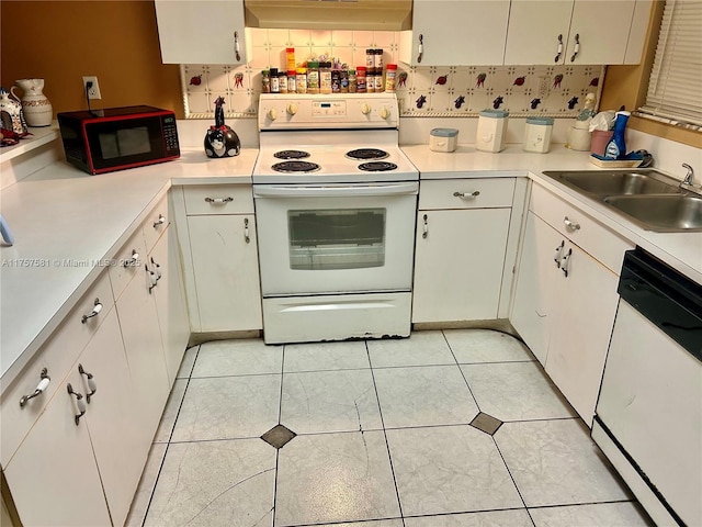 kitchen with under cabinet range hood, light countertops, light tile patterned flooring, white appliances, and a sink