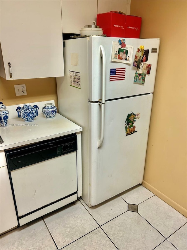 kitchen with white appliances, light countertops, and baseboards