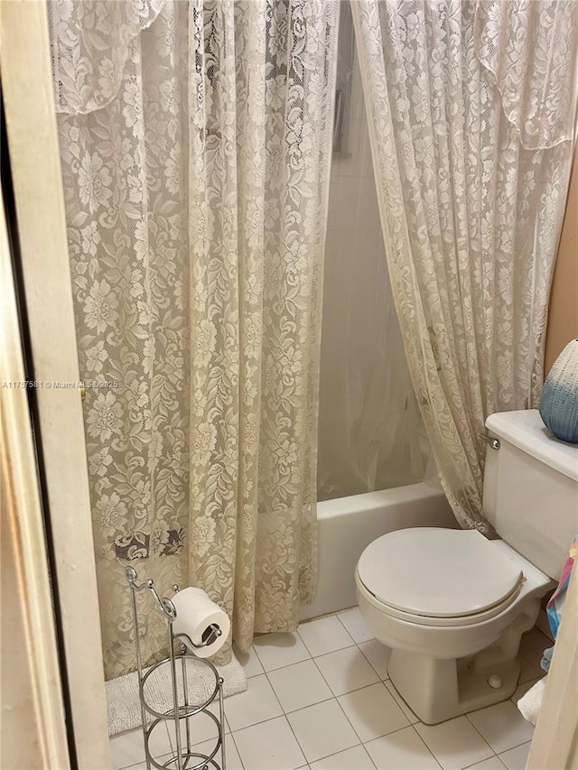 bathroom featuring toilet, shower / bath combo, and tile patterned flooring