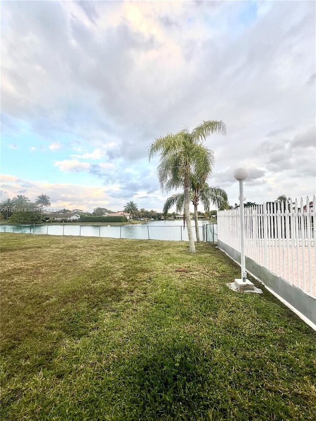 view of yard with fence and a water view