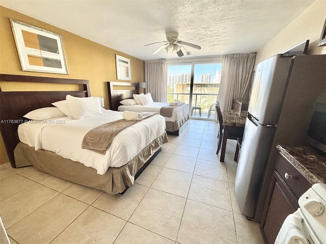 bedroom with a ceiling fan, light tile patterned flooring, freestanding refrigerator, access to exterior, and a textured ceiling