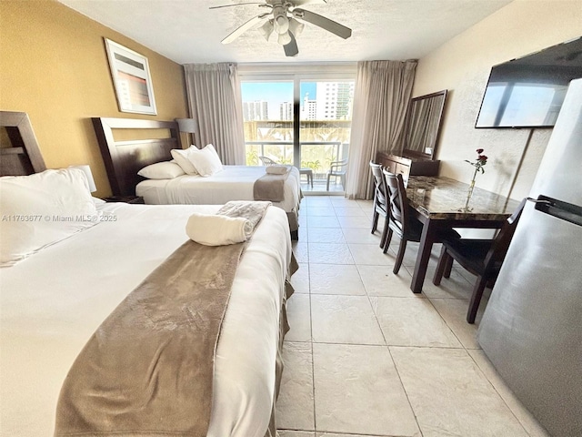 bedroom with light tile patterned floors, freestanding refrigerator, ceiling fan, a textured ceiling, and access to outside