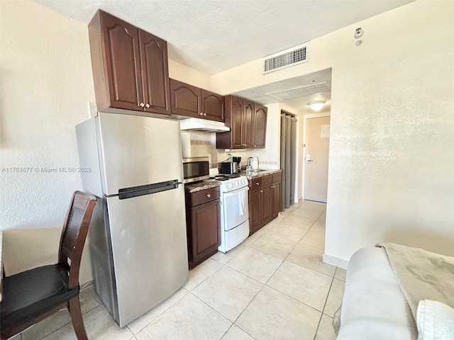 kitchen featuring visible vents, a sink, stainless steel appliances, under cabinet range hood, and a textured ceiling