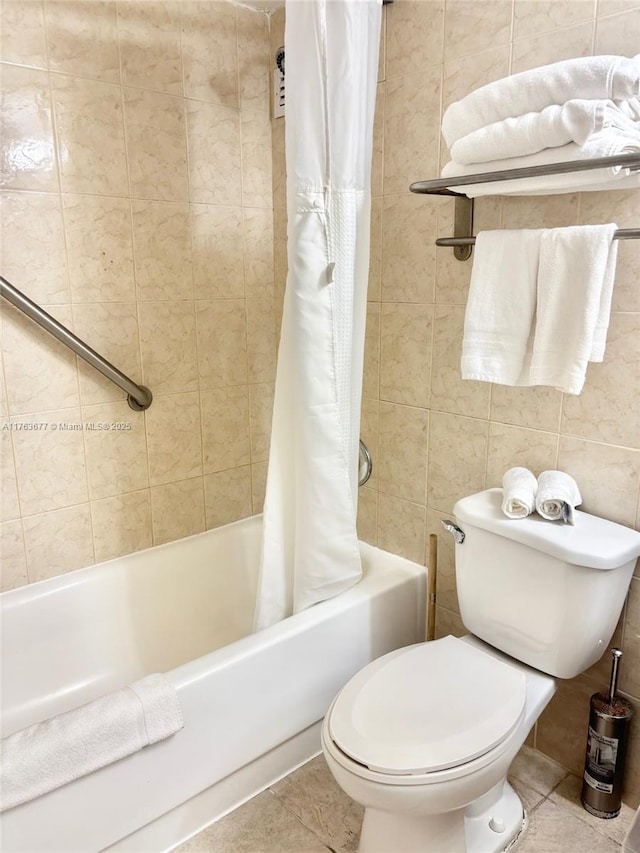 full bath with toilet, tile walls, shower / tub combo, and tile patterned flooring