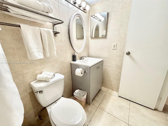 bathroom featuring tile patterned floors, toilet, tile walls, and vanity