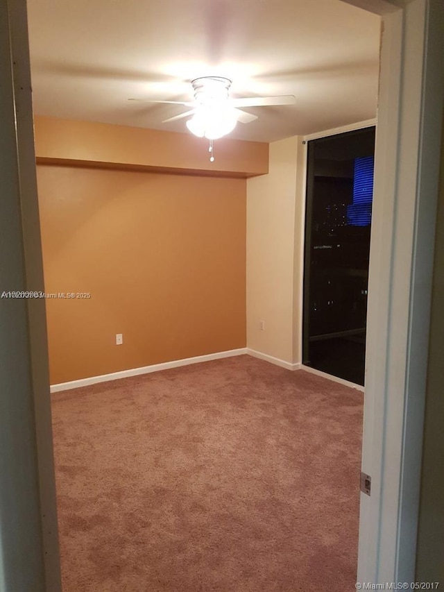 empty room featuring baseboards, carpet floors, and a ceiling fan