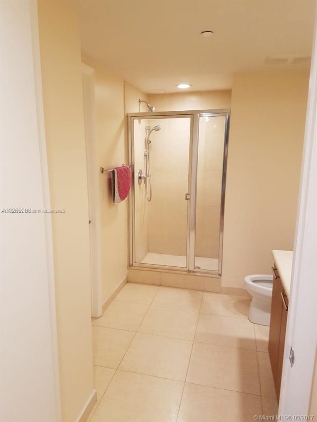 full bath featuring baseboards, toilet, a stall shower, tile patterned floors, and vanity