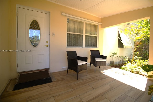 property entrance with stucco siding and covered porch