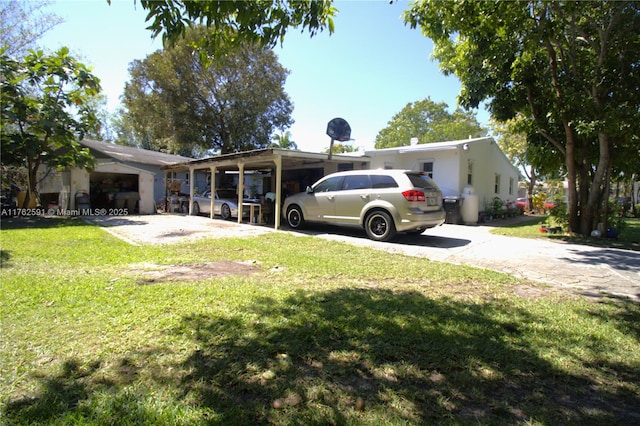 exterior space with a yard, an attached carport, and concrete driveway