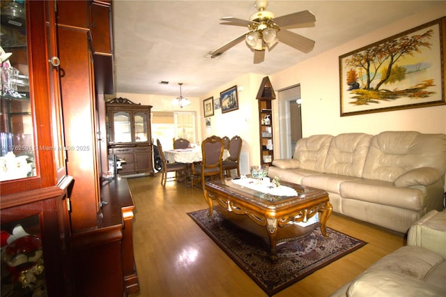 living area with wood finished floors and a ceiling fan