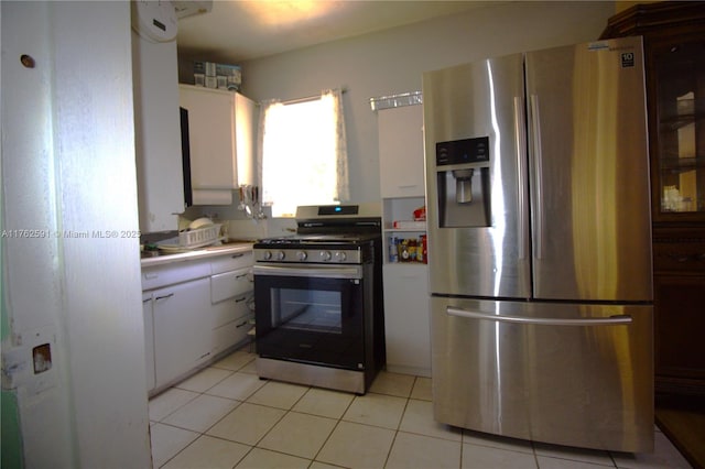 kitchen with light tile patterned floors, stainless steel appliances, light countertops, and white cabinetry