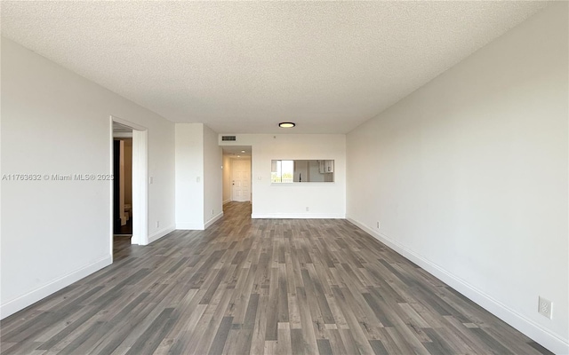 interior space featuring dark wood finished floors, baseboards, visible vents, and a textured ceiling