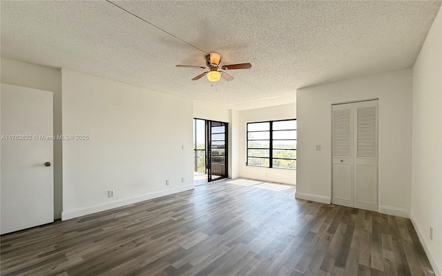 unfurnished bedroom with ceiling fan, wood finished floors, baseboards, and a textured ceiling